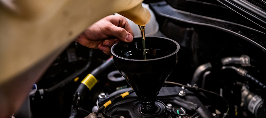 mechanic adding oil with a funnel. how to sell CBD using an expert cbd SEO agency.