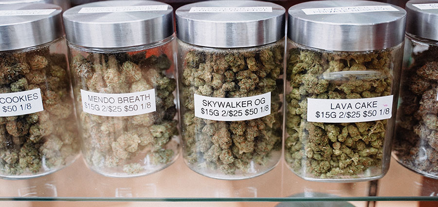 weed buds in glass jars in a marijuana weed dispensary. Cannabis marketing agency.
